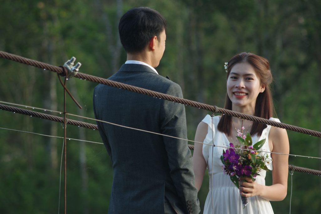 Delighted couple on a bridge, perfect for serene wedding photography and romantic themes.